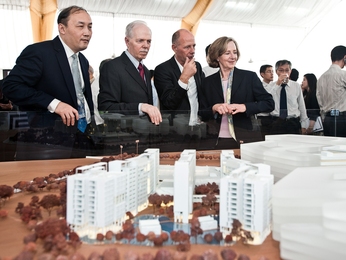 The groundbreaking participants look at a scale model of the SUTD campus.
