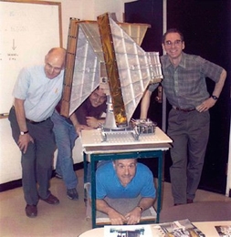 The All-Sky Monitor team assembles around the X-ray monitoring instrument. From left, Hale Bradt, Ed Morgan, Alan Levine; bottom, Ron Remillard.