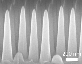 Through a process involving thin layers of material deposited on a surface and then selectively etched away, the MIT team produced a surface covered with tiny cones, each five times taller than their width. This pattern prevents reflections, while at the same time repelling water from the surface.