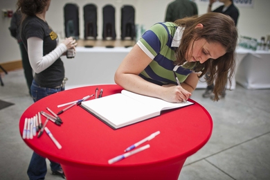 A student signs a guestbook at a student welcome event for President-elect L. Rafael Reif on Wednesday evening.