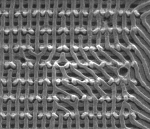 This electron microscope image shows two layers of nanowires produced through the MIT team's self-assembly process, showing how deviations in the pattern and connections between the layers can be included in the design.
