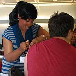 Nicole Napier, M.S.M., B.S.N., R.N., nurse coordinator in MIT Medical's OB/Gyn Service, gives a shot.