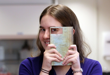 Shannon Taylor holds up an ingot, which is 30 percent by weight copper and 70 percent by weight silver, which is similar composition to some artifacts she studies.