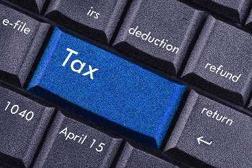 A "tax" button is in the center of a computer keyboard.