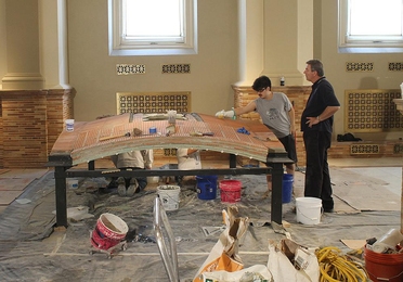 Civil engineering senior Nicky Soane works on the Guastavino vault replica at the Boston Public Library as mason Steve Bolognese looks on.
