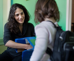 Laura Schulz, primary investigator in the Early Childhood Cognition Lab in the Department of Brain and Cognitive Sciences, works with Madeline Wilson, who is wearing a backpack outfitted with a microphone that records her speech.