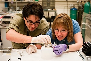 MIT graduate researchers Robert Mitchell and Betar Gallant connect a Li-air battery used to prepare the samples for in-situ Transmission Electron Microscope (TEM) characterization.