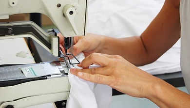 Photo of a hand manipulating cloth in a sewing machine