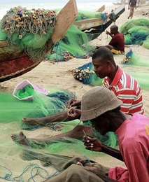 Fishermen weave nets on a seashore in Ghana. This was the winning entry in the 2013 J-PAL and Innovations for Poverty Action staff photo contest.