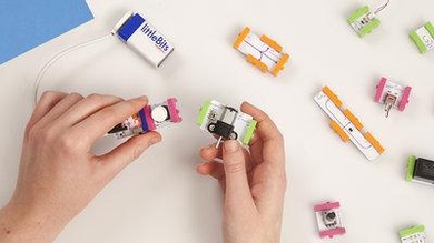 An example of the Bits modules. Here, a power source (blue) connects to a button (pink) that will trigger a motor (green). The orange modules to the side are extending wires.