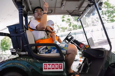Attendees take a spin in one of SMART's driverless golf carts
