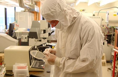 Researcher works in lab while wearing protective lab gear