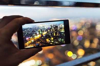 hand holding a smartphone with city lights on the screen