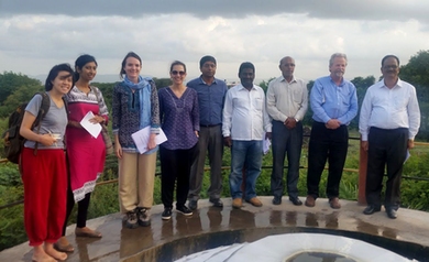 The team poses at a waterworks in Maharashtra, India, with local partners.