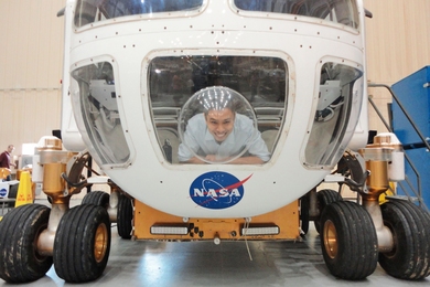 MIT grad student Sydney Do peers from the front window of NASA’s drivable Mars rover prototype at the Johnson Space Center in Houston. 