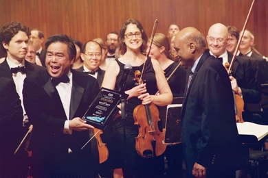 Bhaskar Pant, executive director of MIT Professional Education, presents MITSPO conductor and music director George Ogata with an award of excellence for his years of service.