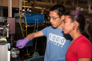 MIT Department of Materials Science and Engineering graduate student Peter Su shows Summer Scholar Ashley Del Valle Morales how to operate a laser and detector system she will use during her summer project under Senior Research Scientist Anuradha Agarwal.