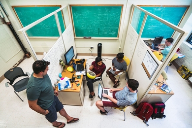 The Hydroswarm team in Building 24: (left to right) Jon Burton, Sampriti Bhattacharyya — holding their prototype submersible robot — Brindha Kanniah, Adam Gawle, and Patrick Flynn.