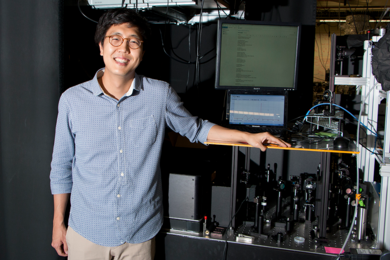 MIT graduate student Changmin Lee stands by an experimental setup that uses light pulses to map the magnetic direction and strength of a buried interface between two exotic materials, bismuth selenide and europium sulfide.