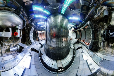 The interior of the fusion experiment Alcator C-Mod at MIT recently broke the plasma pressure record for a magnetic fusion device. The interior of the donut-shaped device confines plasma hotter than the interior of the sun, using high magnetic fields. Postdoc Ted Golfinopoulos, shown here, is performing maintenance between plasma campaigns.