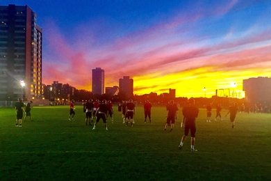 Solar blitz: The MIT Football team practices under stunning skies at Briggs Field. 