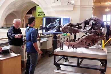 Researchers demonstrate their scanning technique, with a user holding a monopod-mounted Kinect at close range from a T. Rex skull. 
