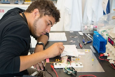 Summer Scholar Alejandro Aponte works on a prototype for a pump that can deliver drugs to the brain. Aponte, a University of Puerto Rico at Mayaguez mechanical engineering major, is working to make the pump small enough to be easily implantable.