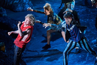 “When’s the last time it felt as if an entire theater were about to levitate?” writes Matt Wolf in the New York Times. “The blissful overdrive of Jay Scheib’s production can affect even a relative outlier — ‘Bat Out of Hell’ is all but blasting an adoring audience out of their seats.” Actors Andrew Polec (left) as Strat, Phoebe Hart (center) as Bessamey, and Isaac Edwards (right)...