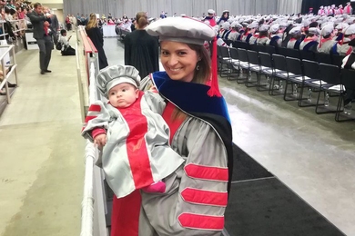 Alejandra Falla PhD '18 holds her newborn, Clara, during the 2018 Commencement exercises. 