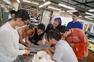 Advanced Fiber workshop participants compare the differences between weft knit and warp knit for sweater construction at FIT in New York City. Pictured (clockwise from left) are Veronica Apsan, Melanie Wong, Jesse Doherty, Erika Anderson, Sebastian Pattinson, David Merchan, and Calvin Zhong. 