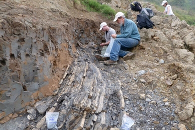 Sam Bowring (front) and former graduate student Seth Burgess inspect the End-Permian extinction horizon at Penglaitan. 