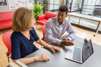 Professor Amy Glasmeier (left) and MIT sophomore Taimor Williams discuss his research project on cascading failures in critical infrastructure systems. Everything from grid design to energy policy to human factors and design influences these types of system failures, and the data surrounding them are immense and complex.