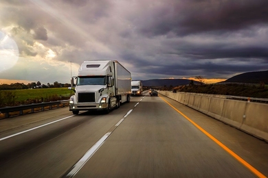 Heavy trucks such as these 18-wheelers contribute a significant fraction of the world’s greenhouse gas emissions. MIT researchers say these emissions could be drastically reduced by using flex-fuel plug-in hybrid powertrains instead of diesel engines.