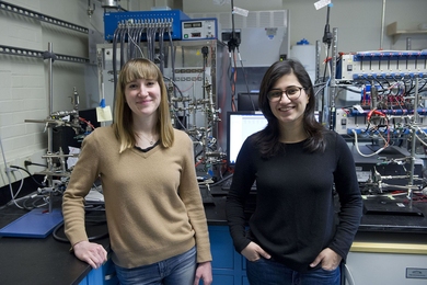 MIT Assistant Professor Betar Gallant (left) and graduate student Aliza Khurram are developing a novel battery that could both capture carbon dioxide in power plant exhaust and convert it to a solid ready for safe disposal. 