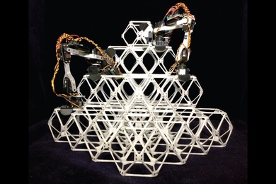 Photo shows two prototype assembler robots at work putting together a series of small units, known as voxels, into a larger structure.