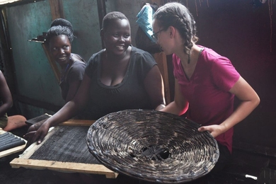 Senior Danielle Gleason (right) speaks with Goretti Ariago (center) and Salume Awiyo (left), employees of Appropriate Energy Saving Technologies, in Soroti, Uganda. Gleason has made two trips to Uganda to help streamline the production of charcoal briquettes which offer a low-smoke alternative for home cooking fuel.