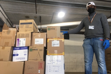 Mail Services Supervisor Darren O’Conner (left) and mail processor Sue Monteiro prepare a shipment of PPE to Mt. Auburn Hospital.