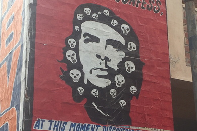 Photo of a mural featuring Che Guevera's face with more than a dozen small skulls painted into his hair 