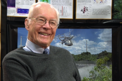 Photo of Gordon Pettengill smiling in front of a series of radio astronomy images and posters