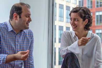 Photo of a man and a woman sitting next to a window and having a conversation