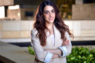 Photo of Dana al Sulaiman standing outdoors in front of a building with her arms crossed