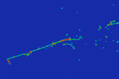 A blue image with a greenish line going from roughly bottom left to top right, with a number of dots and smudges, also greenish, toward the top-right quadrant of the image.