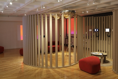 Photo of the virtual storytelling installation gallery with curving brown columns and red bench