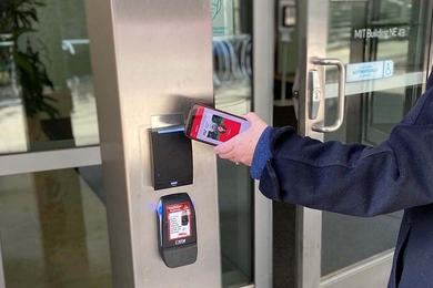 Photo of someone's arm waving a mobile phone at an electronic door lock