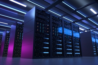 Photo of a bank of supercomputers, which are dimly lit in a dark room with purple and blue light