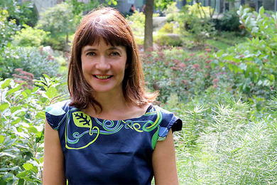 portrait photo of MIT Anthropologist Bettina Stoetzer, who is outside in a verdant garden on a summer day