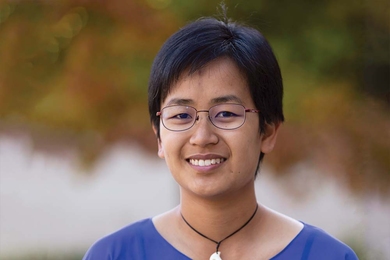 Headshot of Latifah Hamzah against blurred trees. 