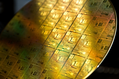 Close-up photo of a silicon wafer with golden semiconductors