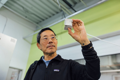Professor Chiang holding up a small cube of decarbonized cement