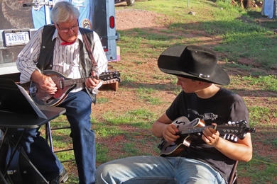 Photo of an older and a younger musician playing a mandolin duet